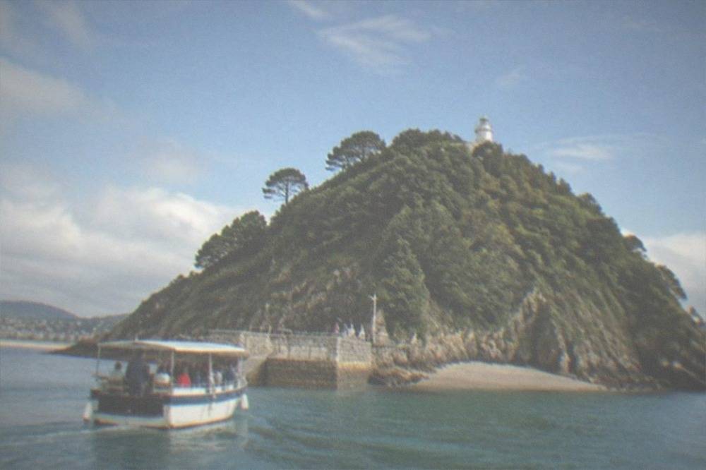 A small passenger boat arriving at the jetty on Santa Clara island with families on board
