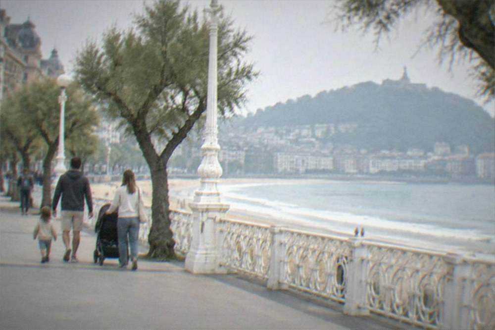 A family with a pushchair walking the seafront promenade between La Concha and Ondarreta beaches