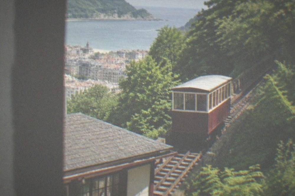 The wooden funicular car climbing the hillside above the rooftops of San Sebastián toward Monte Igueldo