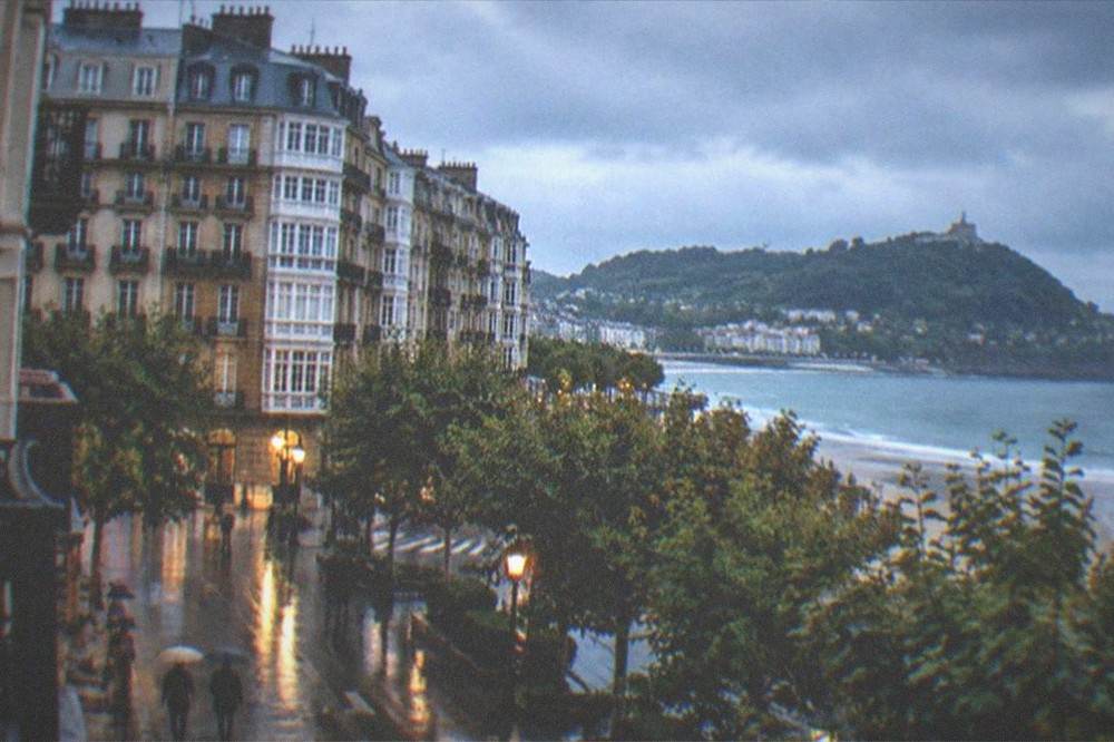 Rain clouds over the rooftops and bay of San Sebastián with wet streets below