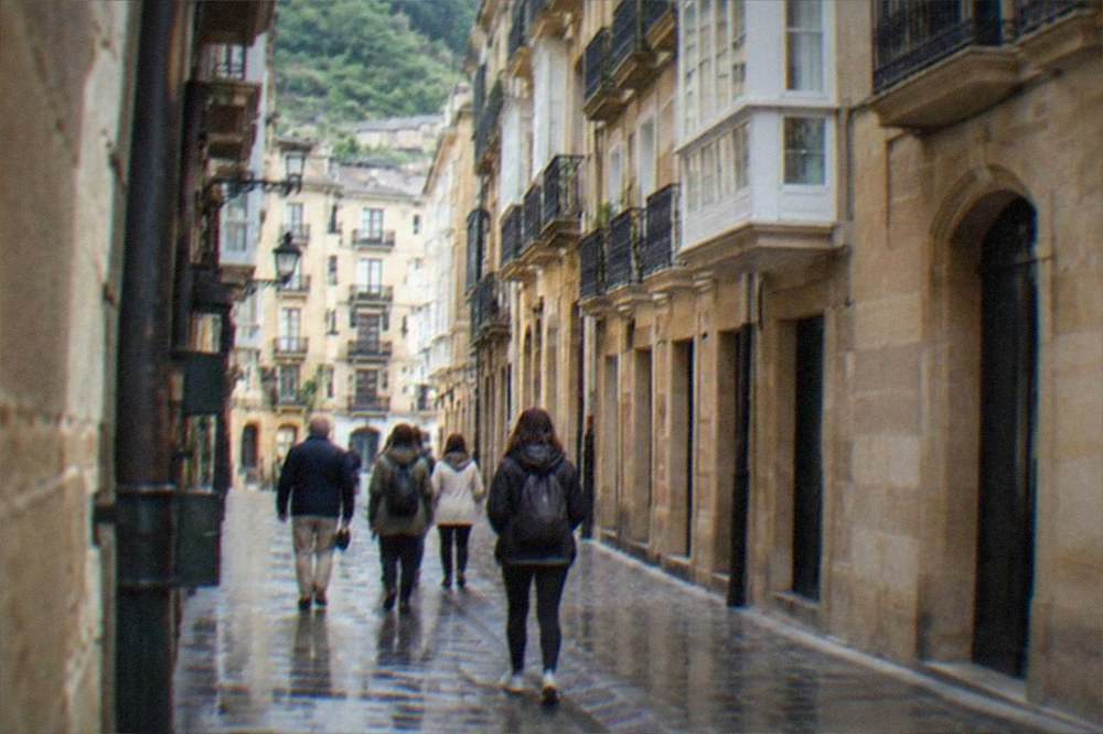 A small tour group walking through a narrow street in the San Sebastián Old Town