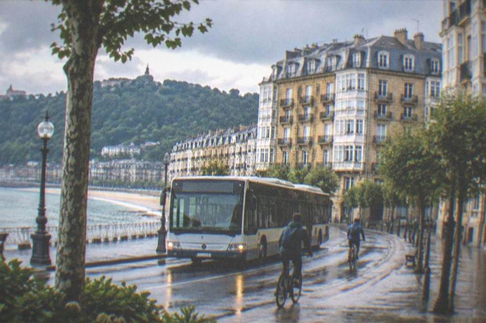 A city bus passing cyclists on a street near the bay in San Sebastián