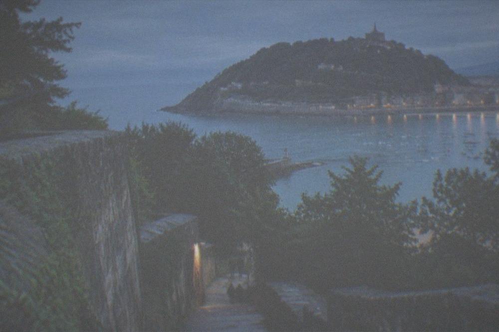The harbour of San Sebastián with boats moored and Monte Urgull rising behind