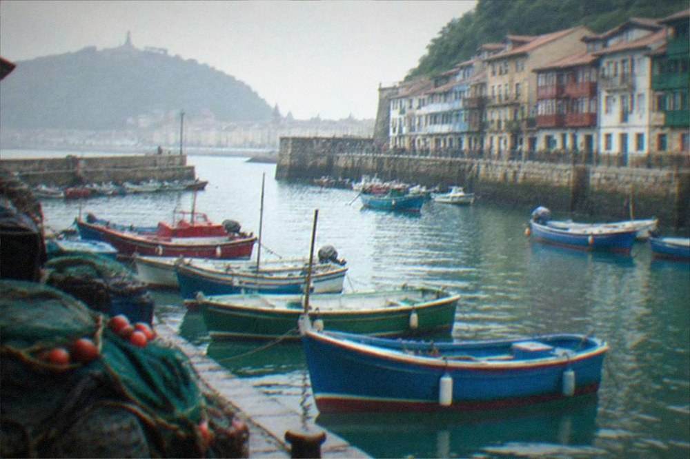 Wooden boats moored in the old harbour with the Parte Vieja buildings behind them