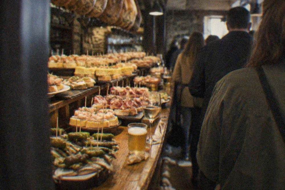 A counter covered with pintxos on small bread slices and skewers