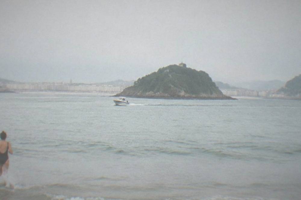Small boat crossing La Concha bay toward Santa Clara island